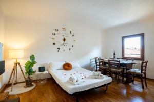 een kamer met een bed en een tafel en een klok bij Centralissimo Bilocale nel Centro Storico in Florence