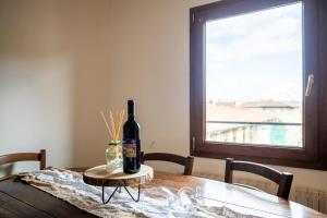 een fles wijn bovenop een houten tafel bij Centralissimo Bilocale nel Centro Storico in Florence