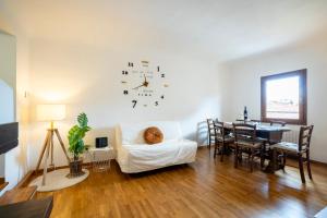 een woonkamer met een tafel en een klok aan de muur bij Centralissimo Bilocale nel Centro Storico in Florence