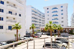 a parking lot with palm trees and buildings at Best Summer Apartment in Golem