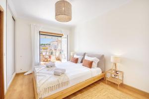 a white bedroom with a large bed and a window at Villa Serenity Tapada - Pool, Cinema Room & Gym in Nazaré +72 photos