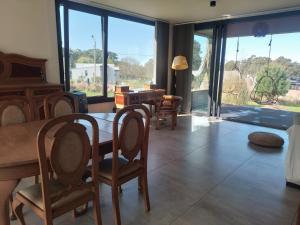 ein Wohnzimmer mit einem Tisch und Stühlen sowie einem großen Fenster in der Unterkunft La Elenitaland in Tandil