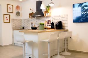 a kitchen with a counter with white stools at Il Nido di Nenna Apartment in Meta +14 photos