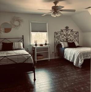 una camera da letto con due letti e un ventilatore a soffitto di Bourbon Barrel Cottages Main House a Lawrenceburg