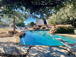 a large blue swimming pool in front of a house at Stunning Country Mansion Estate in SW Fort Worth in Benbrook