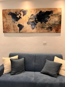 a living room with a blue couch and a world map painting at Trend22 Guest House in Pisa