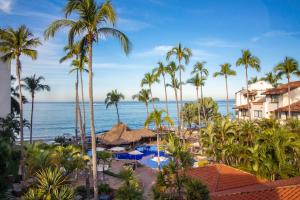 a view of a resort with palm trees and the ocean at Plaza Pelicanos Grand Beach Resort All Inclusive in Puerto Vallarta