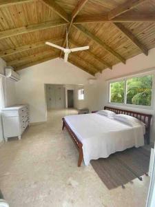 a bedroom with a large bed and a ceiling fan at Hermosa villa en metro country club Juan dolio in Paraíso +26 photos