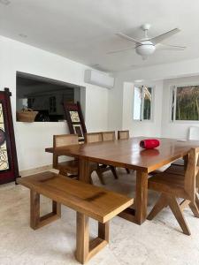 a dining room with a wooden table and benches at Hermosa villa en metro country club Juan dolio in Paraíso
