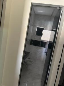 a bathroom with a toilet and a glass door at Rancho Caminho Iluminado in Piumhi