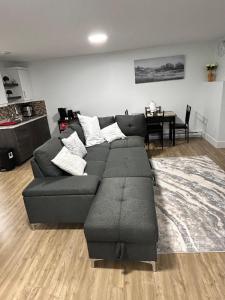a living room with a gray couch and a table at Cozy Bedroom Apartment in Moncton North in Moncton