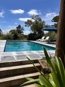 una piscina con sedie e un ombrellone di Loft de Campo en las sierras de Mariscala a Mariscala