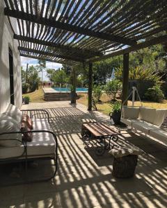 un patio con pergolato, panca e tavolo di Loft de Campo en las sierras de Mariscala a Mariscala