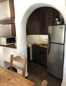 a kitchen with a stainless steel refrigerator and a table at Verano con vistas del atardecer en Casapueblo in Punta del Este