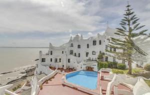 a large white building with a swimming pool next to the ocean at Verano con vistas del atardecer en Casapueblo in Punta del Este