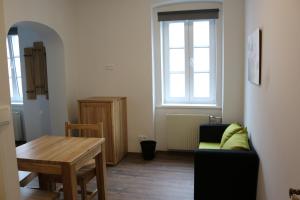 ein Wohnzimmer mit einem Sofa und einem Tisch in der Unterkunft Hotel SINOS in Klagenfurt am Wörthersee