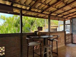 a patio with a table and stools on a porch at Casas Loft Búzios in Búzios