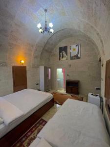a bedroom with two beds and a chandelier at Cappadocia Masuer House in Ürgüp