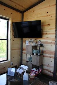 a living room with a flat screen tv in a cabin at Bourbon Barrel Cottages #5 on Ky Bourbon Trail in Lawrenceburg