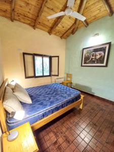 a bedroom with a bed and a ceiling fan at Casa de campo parque Iberá in Colonia Carlos Pellegrini