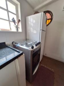 a kitchen with a stove and a white refrigerator at Casas Loft Búzios in Búzios +49 photos