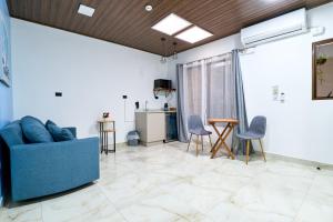 a living room with a blue couch and chairs at APARTAMENTO LA CAPITAL in San José