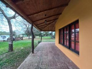 a porch of a building with a wooden roof at Casa de campo parque Iberá in Colonia Carlos Pellegrini +20 photos