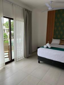 een slaapkamer met een bed en een groot raam bij Hotel Punta Colibrí in Puerto Escondido