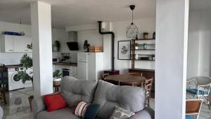 Una sala de estar con un sofá y una cocina. en Casa de la Plata Punta de la Mona, en La Herradura