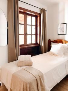 a bedroom with a white bed with a window at Casa Buna Colorada in Playa Blanca +42 photos