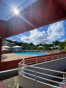 a view of the pool from the balcony of a resort at Studio au soleil levant, avec piscine in La Trinité