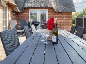 a blue picnic table with a bottle of wine and wine glasses at Luxury Retreat with Pool in Ulfborg