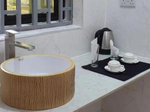 a bathroom counter with a sink and plates and aucer at Jawda in Nungwi