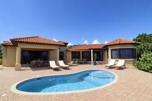 a house with a swimming pool in a yard at Casa Tranquilidad in Willemstad +37 photos
