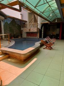 a swimming pool in a building with a patio with chairs at Soleil Suites in Iquitos +27 photos