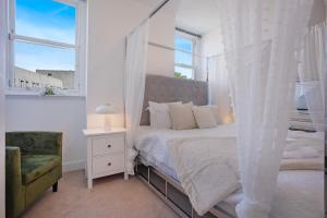 une chambre avec un lit à baldaquin et une chaise dans l'établissement Crimon Place Townhouse - Grampian Lettings Ltd, à Aberdeen