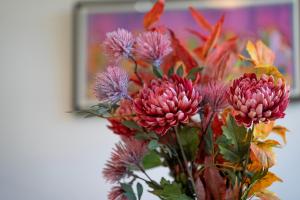 un vase rempli de fleurs roses devant un tableau dans l'établissement Crimon Place Townhouse - Grampian Lettings Ltd, à Aberdeen 36 autres photos