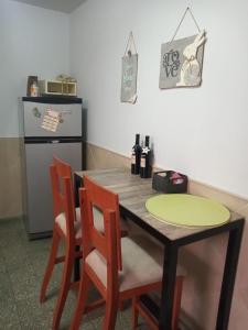 eine Küche mit einem Holztisch mit Stühlen und einem Kühlschrank in der Unterkunft Emilia in Barraquero