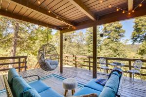 a screened in porch with a couch and a swing at Cabin with Game Room and 2 Decks in Lake Arrowhead! in Lake Arrowhead