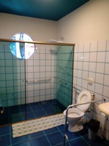 a bathroom with a toilet and a glass shower at Pousada Santa Martha - Suíte Quíntupla - Entre Rios de Minas - MG in João Ribeiro