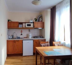 a kitchen with a table and a white refrigerator at Sirena condo 50 m from the central beach in Byala