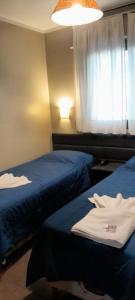 a hotel room with two beds and a window at Hotel Kapac in Mendoza