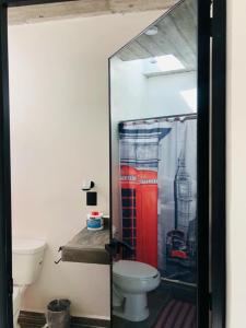 a bathroom with a toilet and a shower curtain at Industrialhaus Alberca privada y climatizada in Ahuatepec