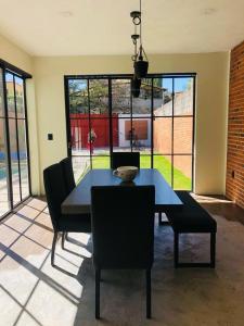 a dining room with a black table and chairs at Industrialhaus Alberca privada y climatizada in Ahuatepec