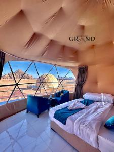 a bedroom with a bed and a view of the desert at WADI RuM GRAND in Wadi Rum