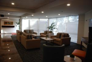 a lobby with couches and tables in a building at Auckland Airport Kiwi Hotel in Auckland