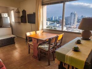 a dining room with a table and a large window at Edificio céntrico en el Este, Torre Gorlero in Punta del Este