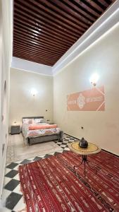 a bedroom with two beds and a table on a rug at Dar hiba in Océan +21 photos