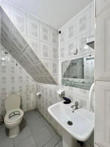 a white bathroom with a sink and a toilet at Dar hiba in Océan