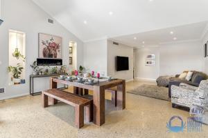 a living room with a table and a couch at Soldiers Cove Luxury Retreat in Mandurah